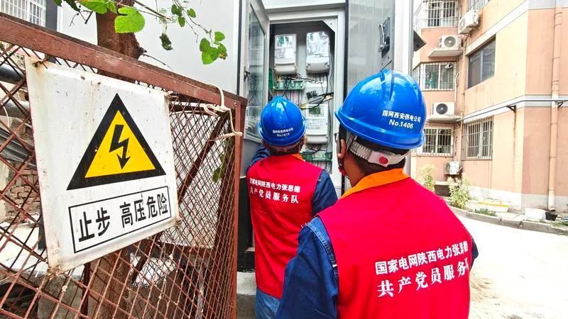 灞桥区一老旧小区内，电力工作者对箱式变压器进行检修。