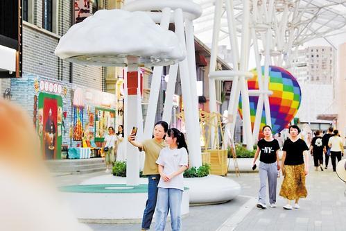 7月18日，游客在唐山市路南区建国里商业街区游玩。 本报记者 师源摄