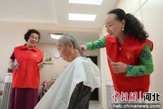 图为银龄志愿者正在为高龄老人理发。 王倩倩 摄