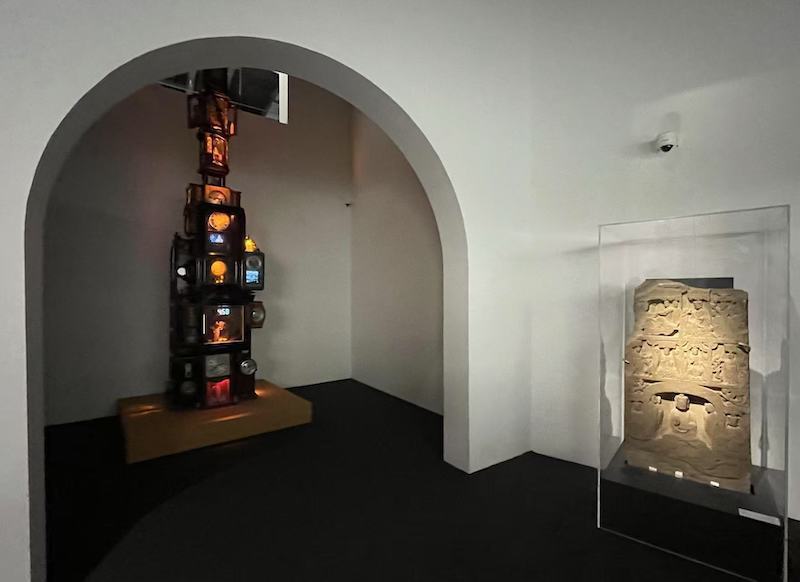 展览现场,马良作品《银河》(左)与北魏石造像碑。