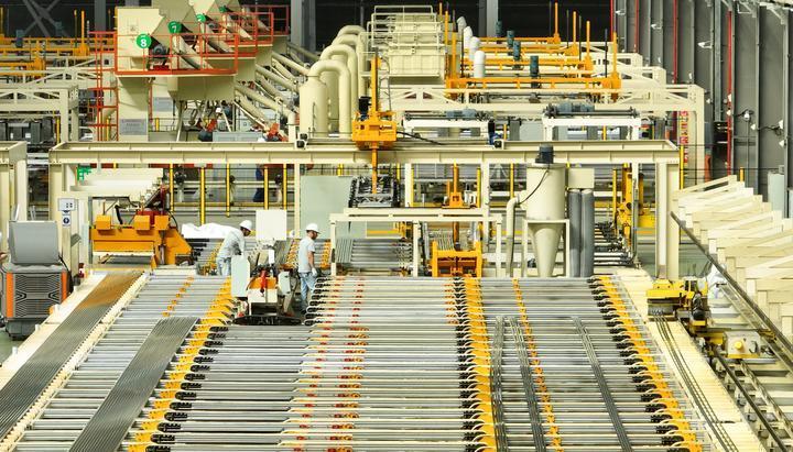 丰城市晶科光伏材料有限公司员工在太阳能板铝合金边框挤压生产线上生产。