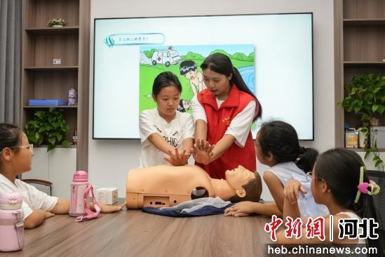 图为大学生志愿者正在为小朋友普及防溺水知识。 王倩倩 摄