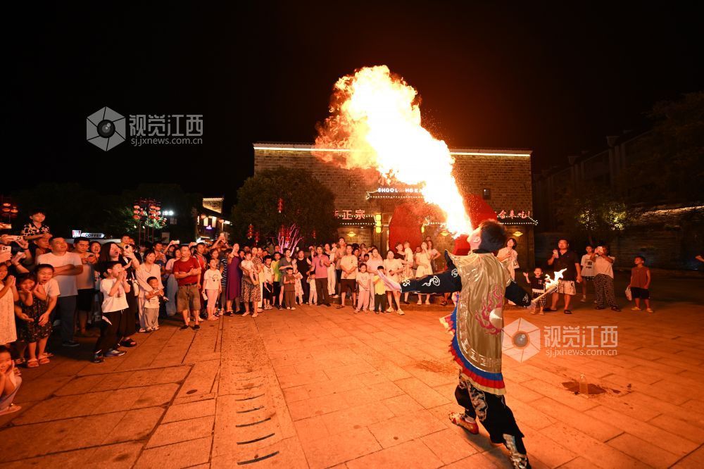 7月16日晚,游客在抚州文昌里历史文化街区欣赏喷火表演。(江西日报全媒体记者 吴文兵 摄)
