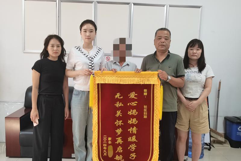 孩子家长给社区妇联和李亚娟（左二）送来锦旗表示感谢