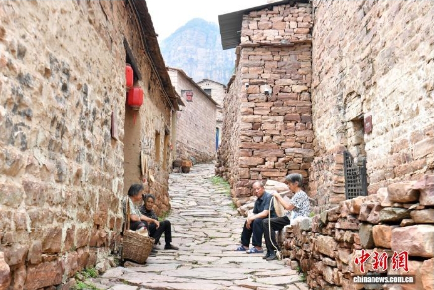 7月9日,河北省邢台市信都区英谈村村民在家门口休息。中新社记者 韩冰 摄