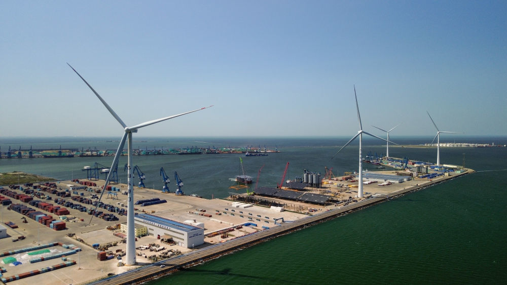 在山东潍坊港，风力发电机为港区提供电力（2025年6月12日摄，无人机照片）。新华社记者 徐速绘 摄