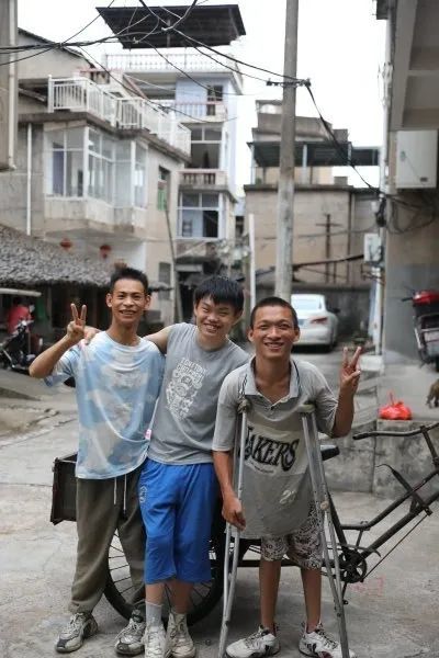 三名少年在家门前灿烂微笑。图/九派新闻记者 乔彦杰