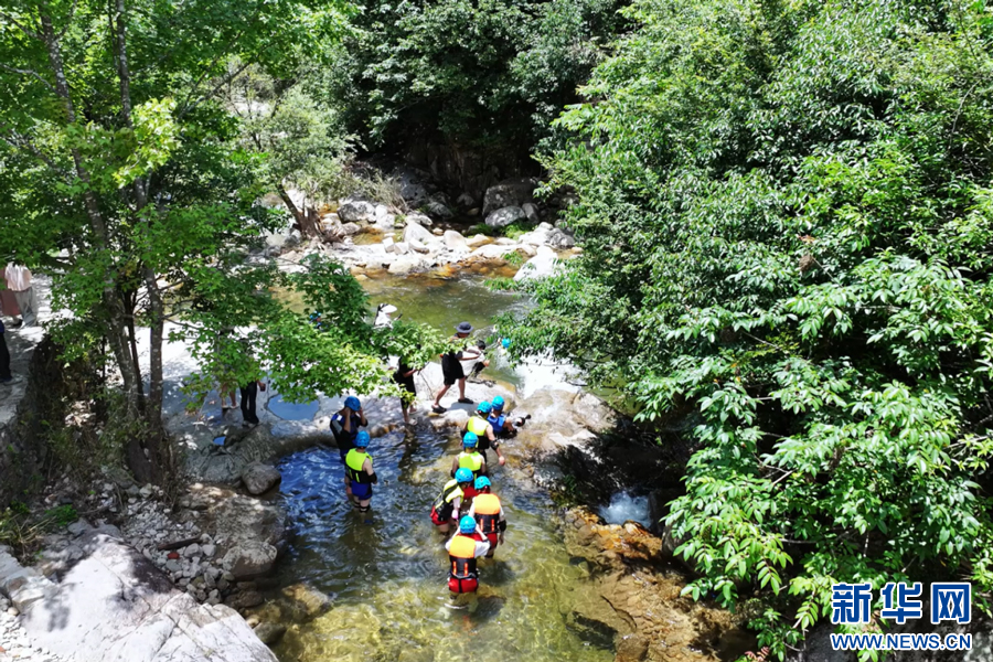 游客们徜徉山水间，与水为伴，乐享清凉。新华网发