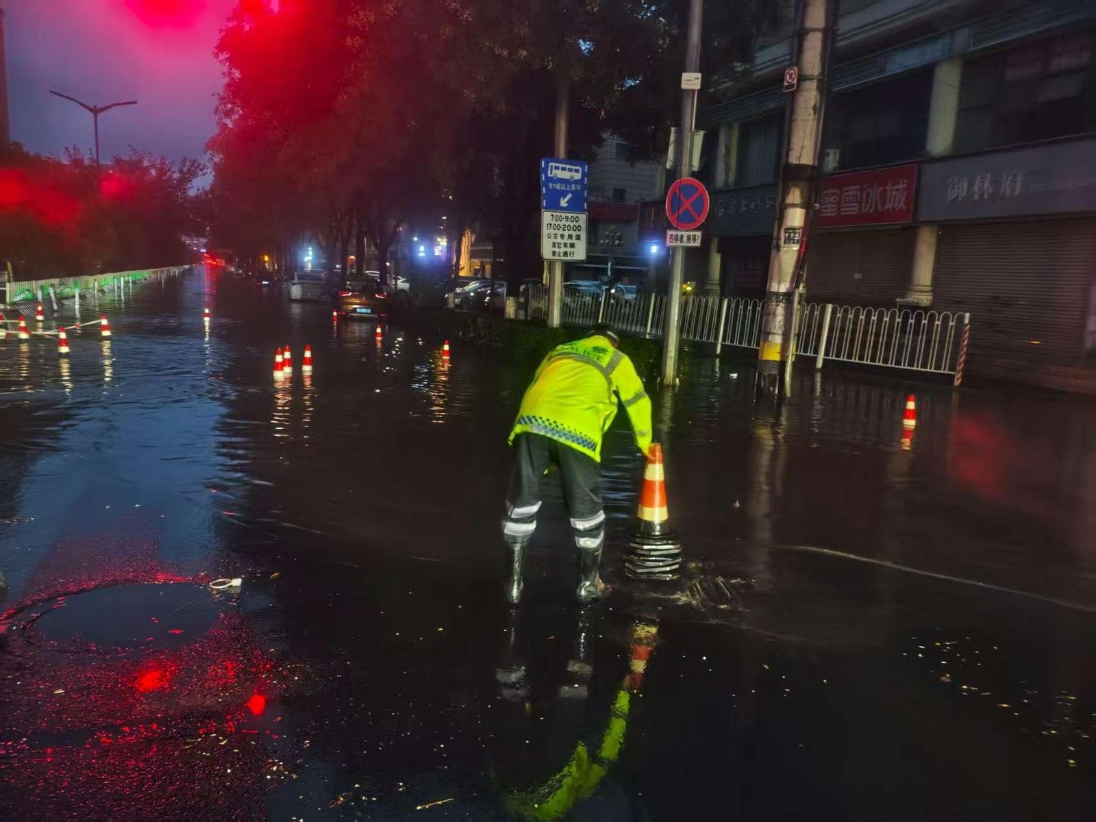 交警在积水路段摆放反光锥桶