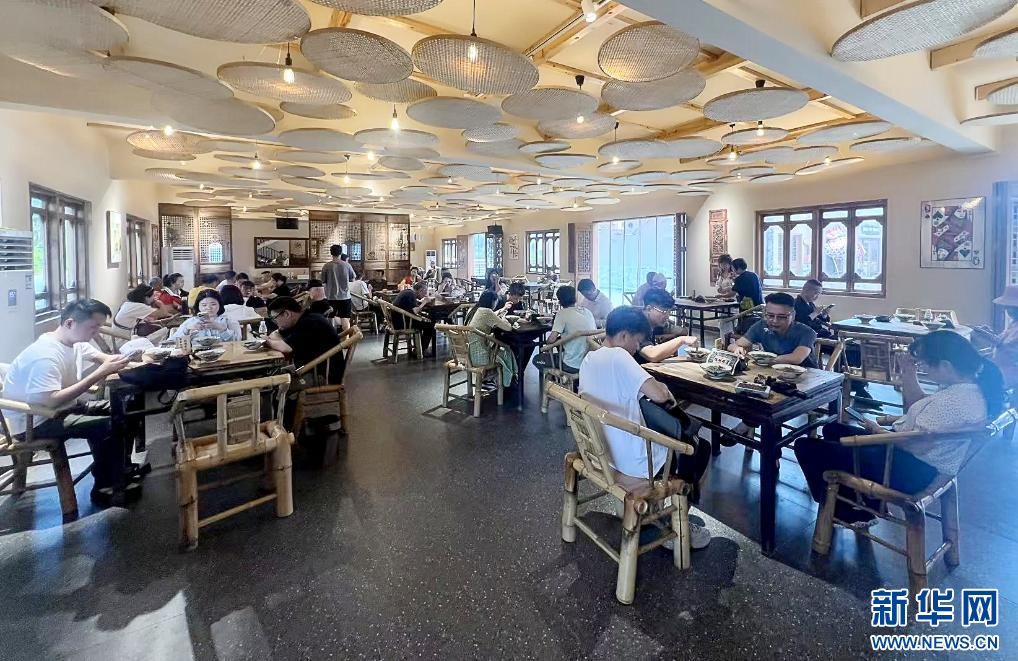 在江西定南客家古城景區，游客圍坐品嘗大碗茶。新華網 王曉震 攝
