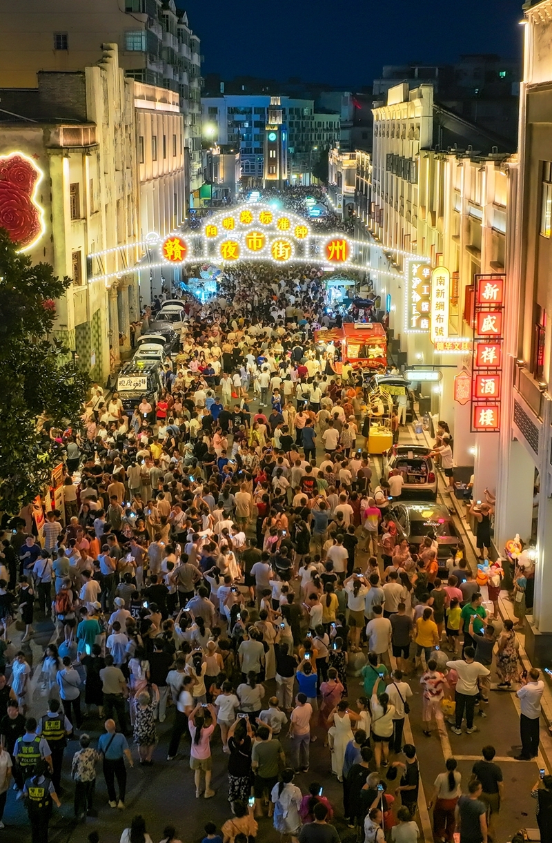7月25日晚,赣州阳明路标准钟夜市街人流如织,热闹非凡。