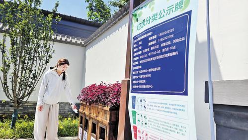 7月22日，在定州东亭镇翟城村历史文化街区，游客向垃圾桶分类投放垃圾。 本报记者林凤斌摄