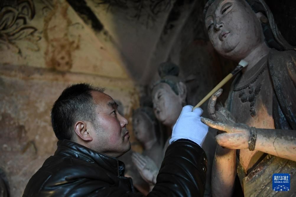 牟常有在麦积山石窟11窟内修复塑像（2019年12月25日摄）新华社记者　马宁　摄