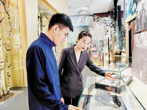 7月31日,王雪彦(右)在塞罕坝展览馆给参观者讲解。受访者供图