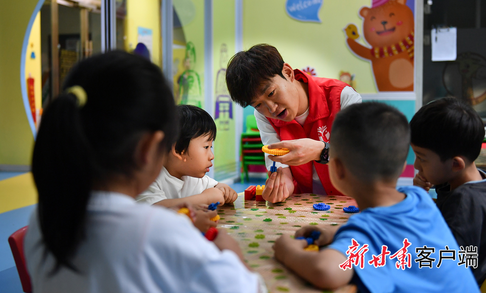 大学生志愿者和孩子们拼接模型