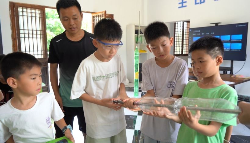 王印带学生用身边的材料制作水火箭。周雪莉/摄