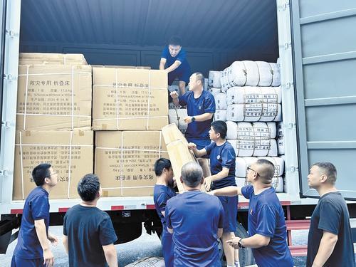 7月29日，阜平县应急管理局工作人员正在搬运救灾物资。 周新皓摄