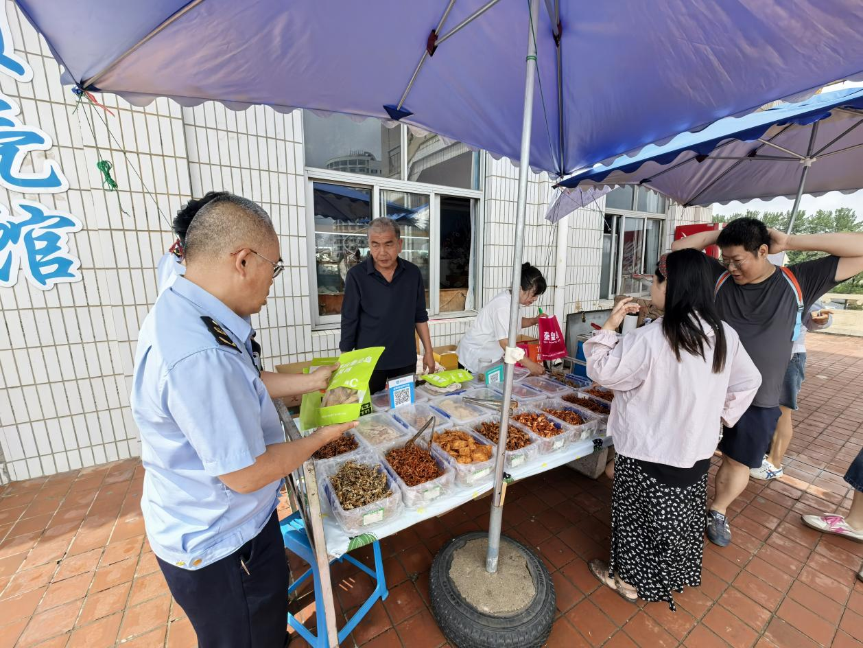 （图为执法人员检查农村食品小摊点 赵慧玲供图）