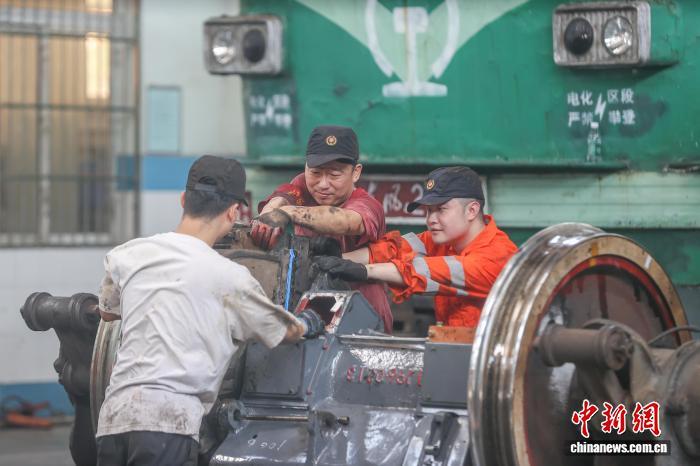 7月30日，江西南昌縣向塘機(jī)務(wù)段，鐵路工作人員在對機(jī)車車輪開展檢修。中新社記者 劉力鑫 攝