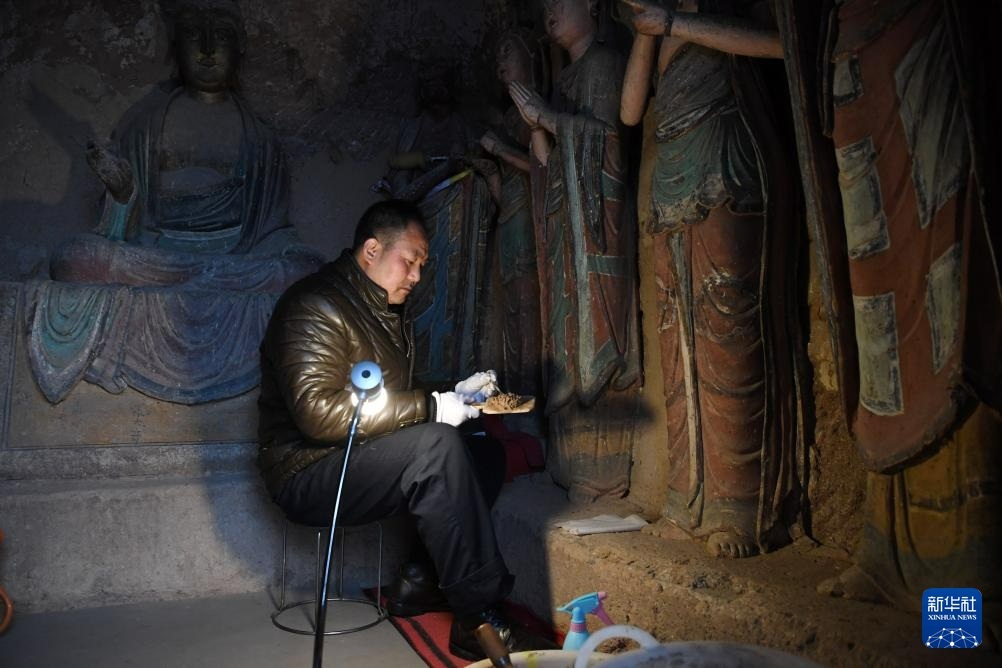 牟常有在麦积山石窟11窟内修复塑像（2019年12月25日摄）新华社记者　马宁　摄