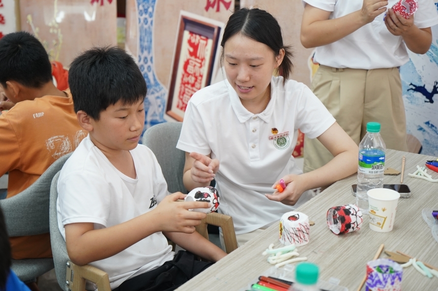 实践团队协助小朋友完成手工艺品。