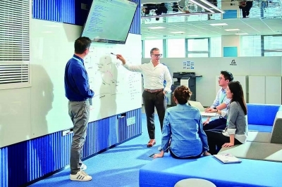 在宝马全球信息技术研发中心,员工正讨论技术方案。 受访者供图