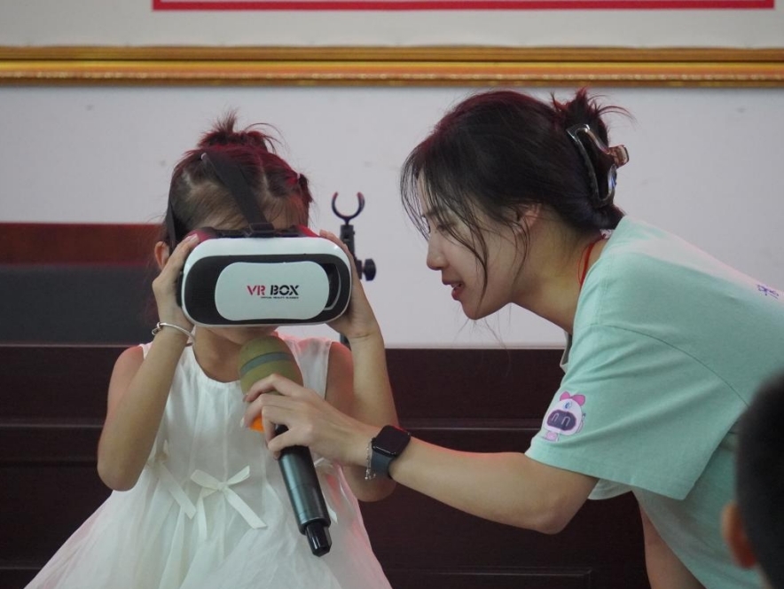 实践队引导孩子们佩戴体验VR设备。
