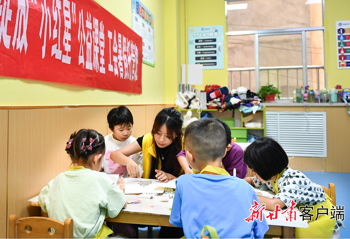 大学生志愿者和孩子们一起做贴画