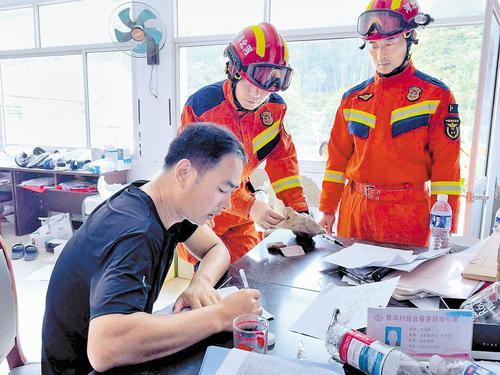 7月31日，董建国（左一）接收消防救援队员捡到的现金。本报记者 陈宝云摄