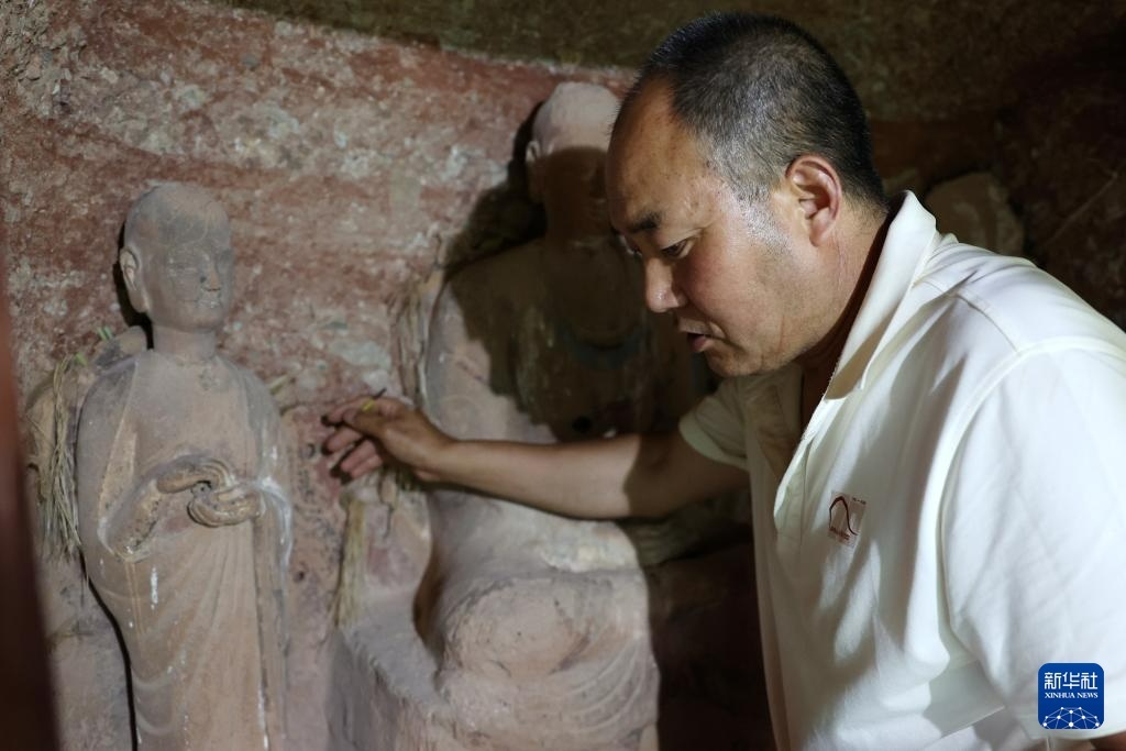 牟常有在麦积山石窟157窟查看塑像情况（7月16日摄）新华社记者　陈斌　摄