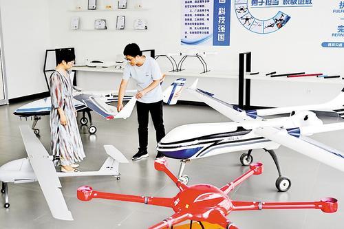 7月21日，恒润集团有限公司飞行器设计中心，工程师（右）向客户介绍新型复合材料生产的无人机。