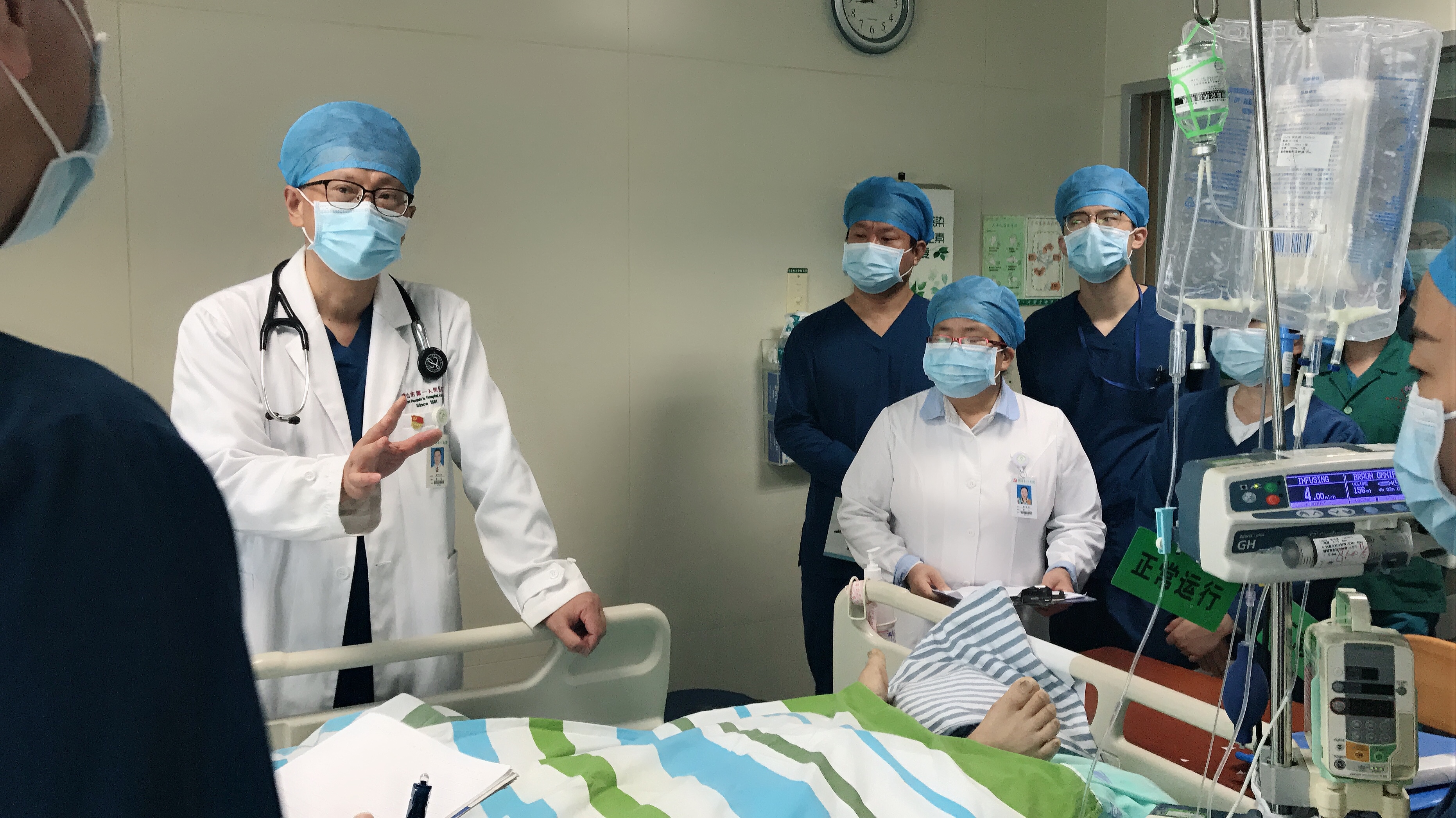 图为:周立新带领ICU团队讨论患者治疗方案。