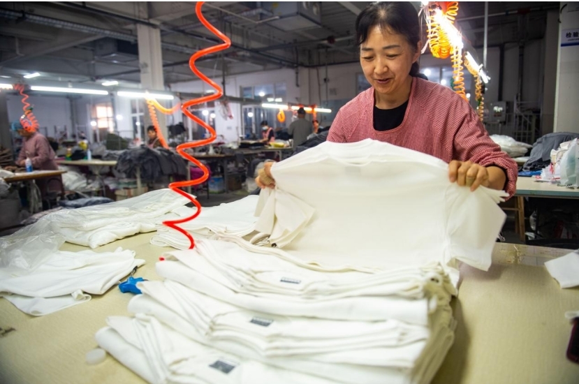 工人在整理服装产品。傅新春 摄