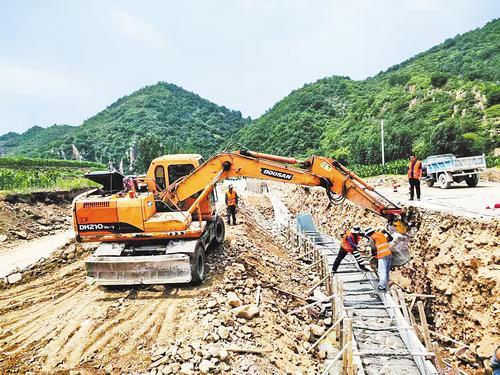7月11日,在海港区驻操营镇小河营村一处道路施工现场,工人在修建混凝土挡墙。本报记者 宋柏松摄
