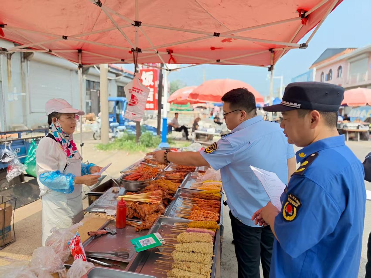（图为执法人员检查农村大集食品摊点 赵慧玲供图）