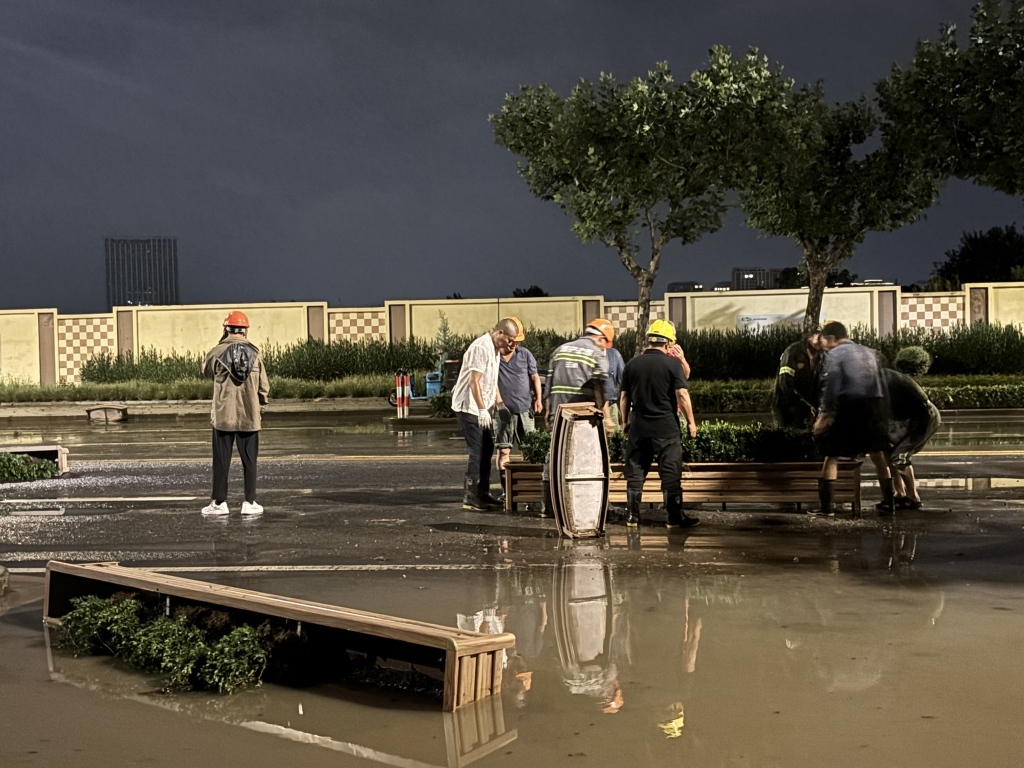 7月31日22时30分左右，普陀市政工作人员正在处理积水和绿化隔离带。澎湃新闻记者 邹佳雯 图