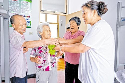 8月1日，兴隆二中安置点，朱家沟村村民史春华（右一）把清洗好的葡萄分给邻居。本报见习记者 张 昊摄