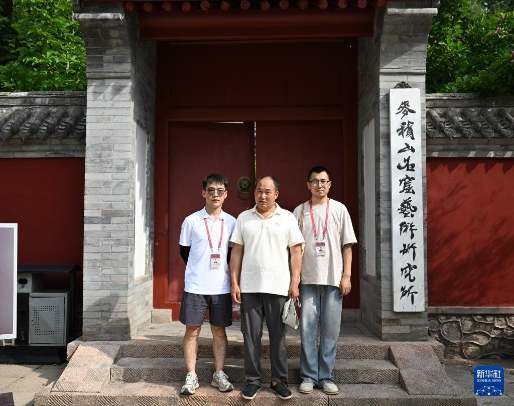 完成一天修复工作的牟常有（中）与徒弟李浩亮（右）、于佑樘在麦积山石窟艺术研究所前合影（7月16日摄）新华社记者　蔡湘鑫　摄