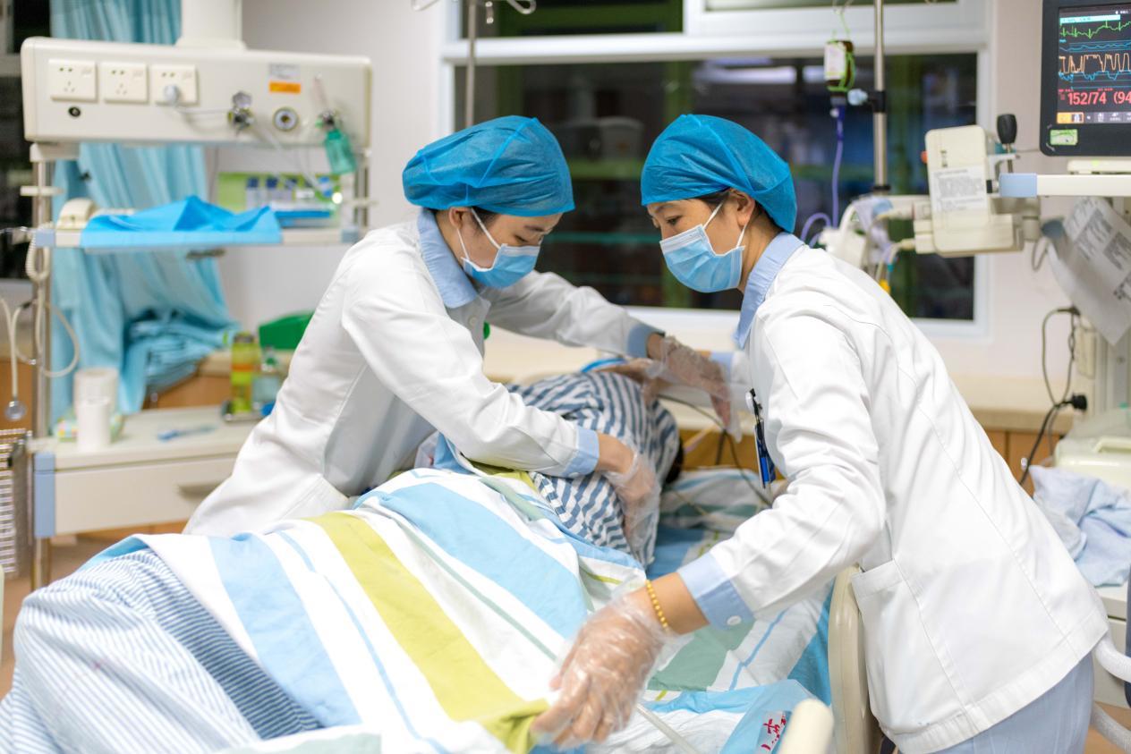 图为:ICU医护人员为患者进行精细护理。