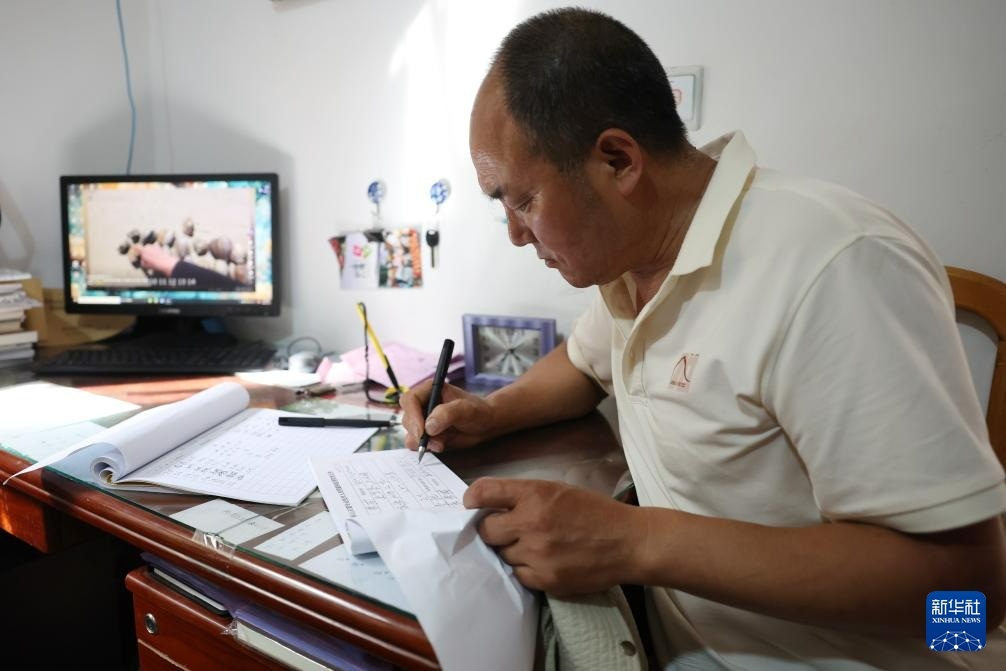 一天的修复工作结束后，牟常有在麦积山石窟艺术研究所保卫部门填写石窟钥匙交还表（7月16日摄）。新华社记者　陈斌　摄