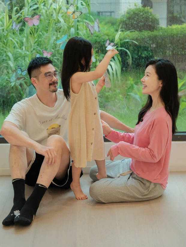 杨子姗夫妻俩看着女儿玩耍，面露开心笑容，爱意满满。