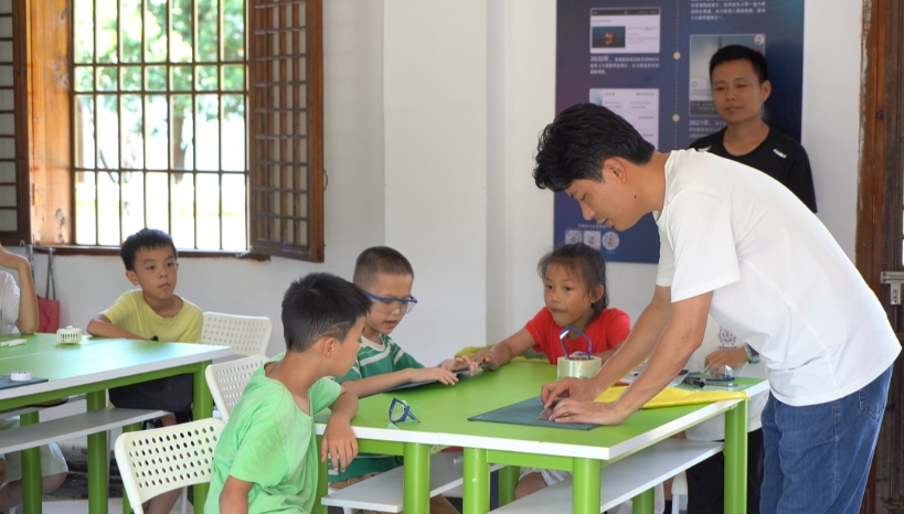 王印和孩子们一起研究水火箭降落伞的制作。周雪莉/摄