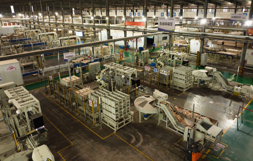 机器在南康家具智能备料中心生产线上自动加工木料。