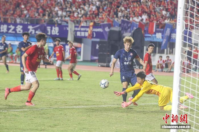8月2日，江西鹰潭，鹰潭队门将(黄衣)倒地防守九江队球员(蓝衣)的射门。中新社记者 刘力鑫 摄