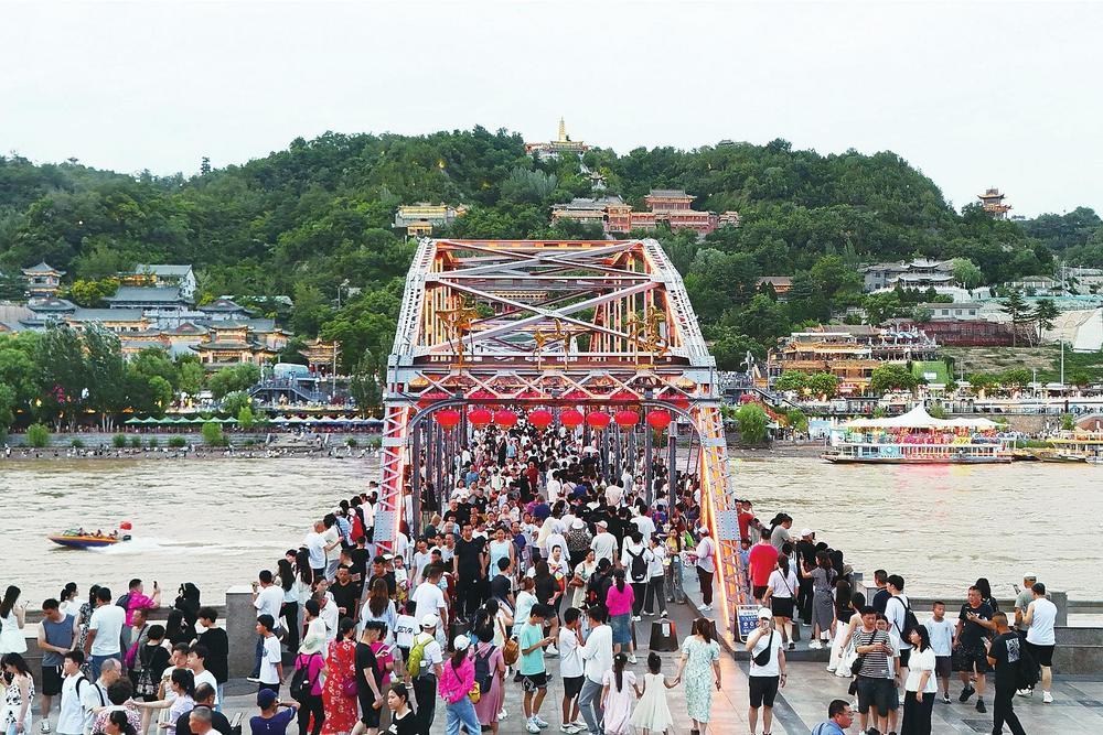 美丽的黄河之滨吸引了众多游客,兰州中山桥上人潮涌动。