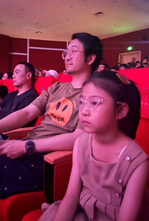 父女观众沉浸在扣人心弦的剧情中