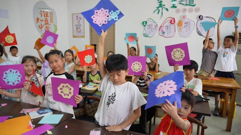 孩子们在幸福学堂里学习手工剪纸。