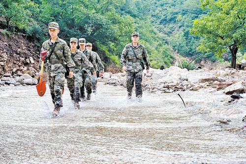 8月1日，武警河北总队承德支队的官兵踏水前行，向朱家沟深处挺进，执行搜救任务。 本报记者 郭宝强摄