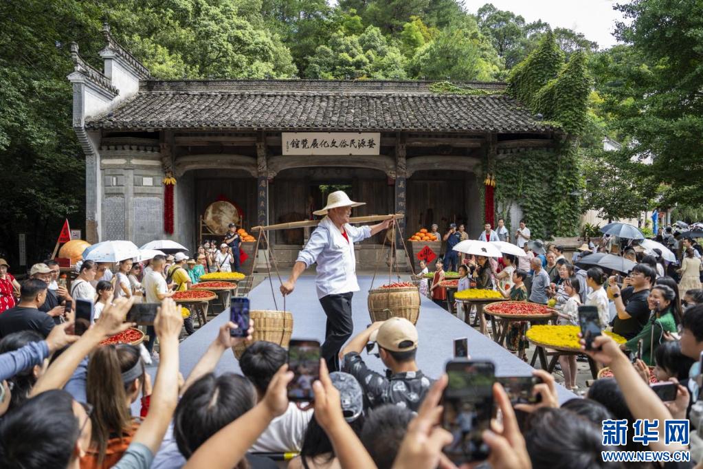 篁岭村民挑着丰收的辣椒、皇菊，在T台上自信地展示。新华网发