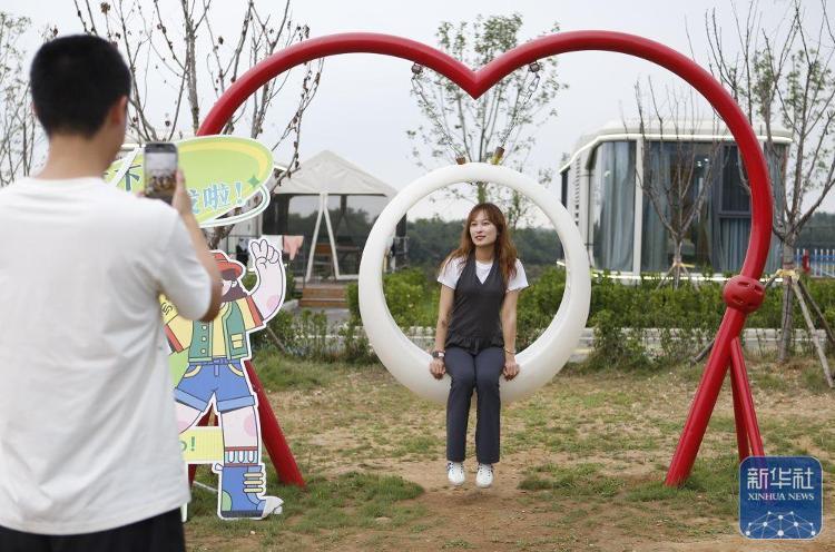 ↑ 8月5日，游客在莱西市南墅镇青山绣湖旅游度假区拍照打卡。